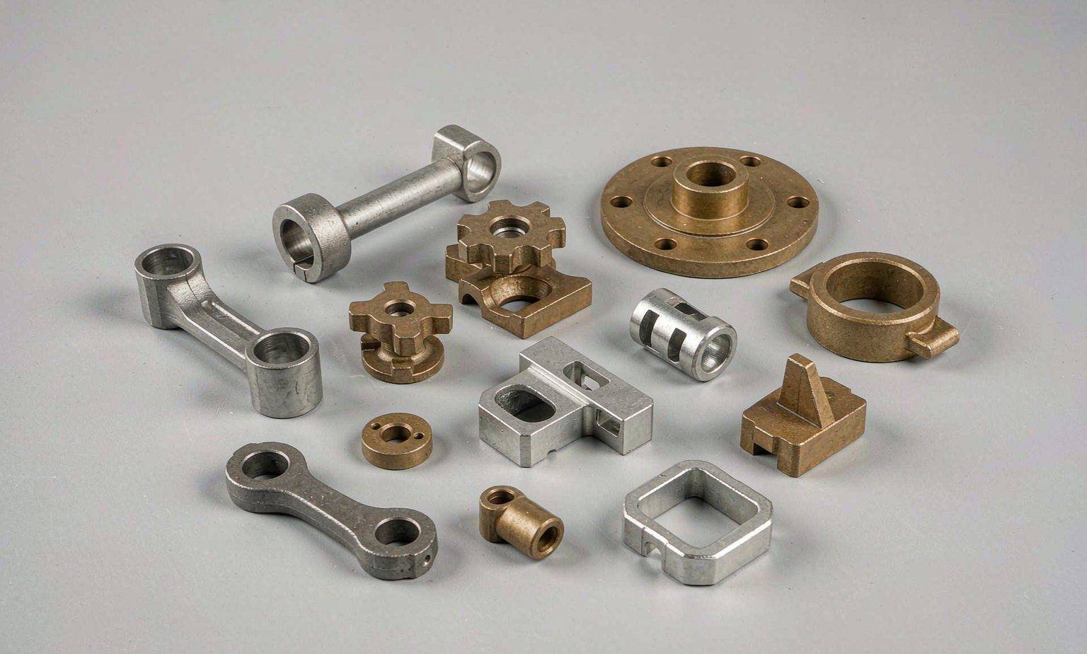 Sintered structural powder metal components including connecting rods, flanges, brackets and cams.